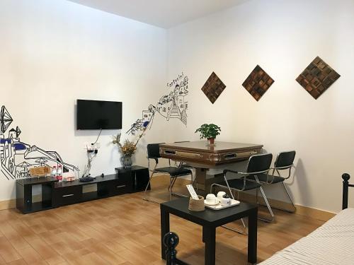 ein Wohnzimmer mit einem Tisch und einem TV in der Unterkunft Lin Jiang Apartment in Guangzhou