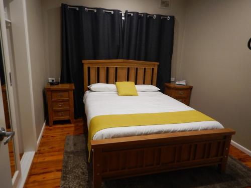 a bedroom with a bed with a yellow pillow on it at Manera Heights Apartments in Dubbo