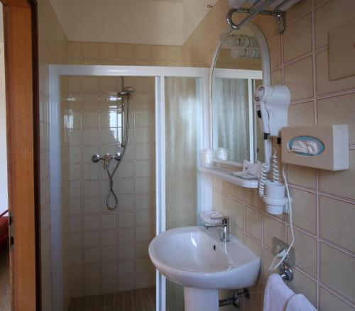 a bathroom with a sink and a shower with a mirror at Hotel Roby in Lido di Jesolo