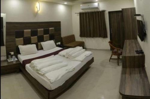 a bedroom with a large bed in a room at Hotel Shree Vatika in Bhopal