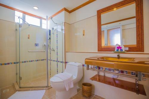 y baño con aseo, lavabo y ducha. en Loei Village Hotel, en Loei