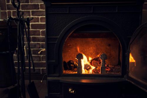 a brick fireplace with a fire in it at IZA Kamakura Guest House and Bar in Kamakura