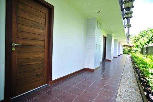a hallway of a building with a wooden door at Chalong Beach Front Residence in Rawai Beach