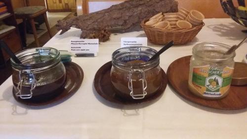 a table with two jars of honey and a basket of bread at Hotel Angerer in Vilseck