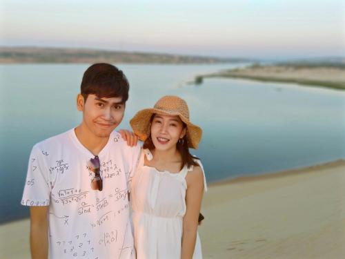 a man and a woman standing on the beach at Lang Chai Guesthouse in Mui Ne