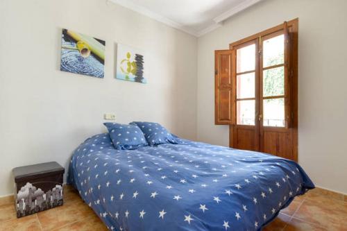 - une chambre avec un lit doté de draps bleus et une fenêtre dans l'établissement Apartamento en pleno centro, WIFI, ideal, à Grenade