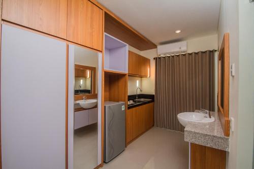 een badkamer met 2 wastafels, een douche en een wastafel bij Anindya Homestay in Sanur