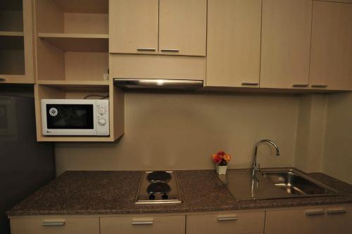 a kitchen with a sink and a microwave at Chalong Beach Front Residence in Rawai Beach