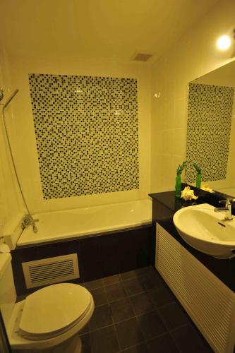 a bathroom with a toilet and a tub and a sink at Chalong Beach Front Residence in Rawai Beach
