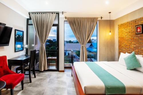 a bedroom with a bed and a desk and a window at CENTRAL BLANCHE Residence in Siem Reap