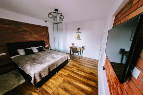 a bedroom with a bed and a brick wall at Apartament Barbara in Gdańsk