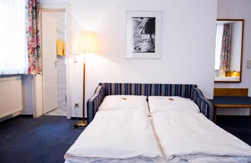a bed in a small room with a lamp at Hotel am Rathaus in Heidelberg