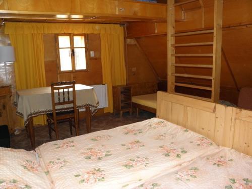 una camera con due letti e un tavolo e una sala da pranzo di Chalupa u lesa a Červená Voda
