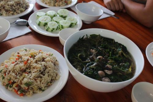 a table topped with bowls of food and rice at Cham Island Smiles Homestay in Tân Hiệp