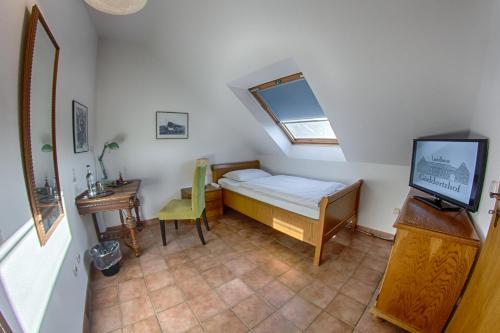 a small bedroom with a bed and a television at Landhaus Göddertzhof in Erkelenz