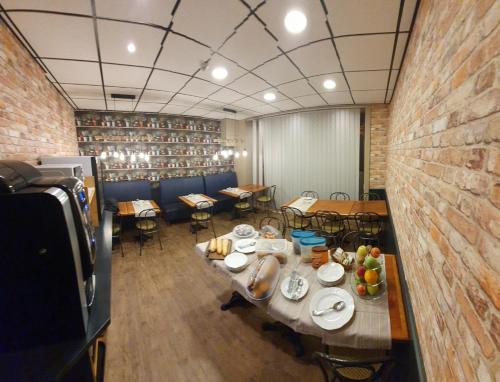 a dining room with a table and chairs and a brick wall at Hôtel de la Poste in Limoges