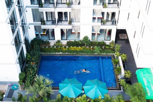 an overhead view of a swimming pool in a building with umbrellas at CENTRAL BLANCHE Residence in Siem Reap