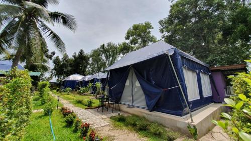 a row of blue tents in a garden at Moonshine Resort Chumphon in Chumphon
