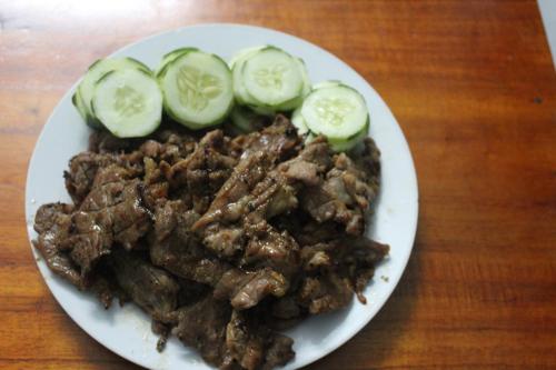 a plate of food with meat and cucumbers on it at Cham Island Smiles Homestay in Tân Hiệp