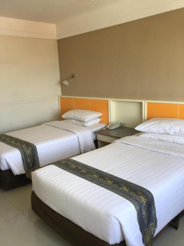Una cama o camas en una habitación de Tonkoon Hotel