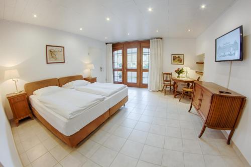 a bedroom with a large bed and a table at Landhaus Göddertzhof in Erkelenz