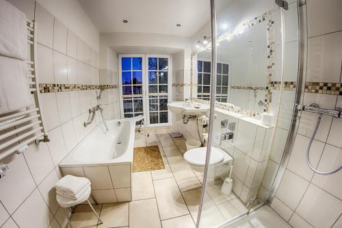 ein Badezimmer mit einer Badewanne, einem Waschbecken und einem WC in der Unterkunft Landhaus Göddertzhof in Erkelenz