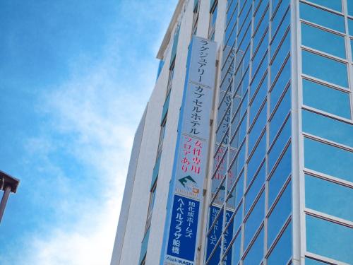 a tall building with signs on the side of it at Leo Yu Capsule Hotel Funabashi in Funabashi