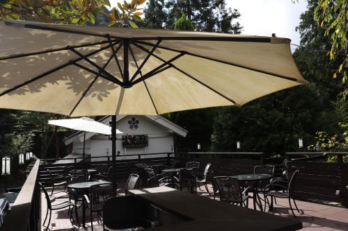 a group of tables and chairs with an umbrella at Temple Lodging Shukubo Kakurinbo in Minobu