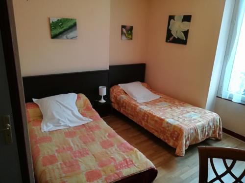 two beds in a small room with two beds at Hôtel de la Poste in Limoges