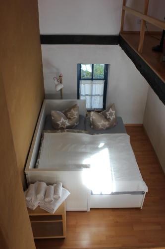 a large white bed in a small room at Romantische Ferienhaus an der Ostsee mit großem Garten in Rerik