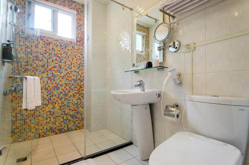 a bathroom with a shower and a toilet and a sink at Butchard Villas in Yuchi