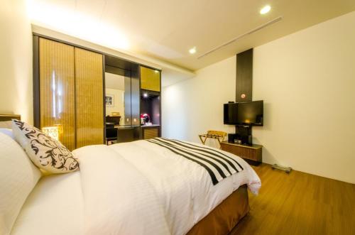 a hotel room with a bed and a television at Butchard Villas in Yuchi
