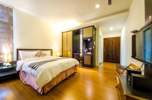 a bedroom with a bed and a flat screen tv at Butchard Villas in Yuchi