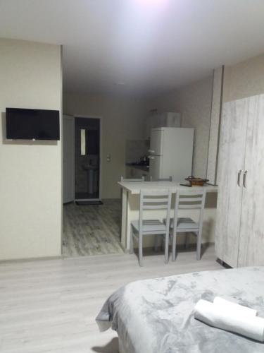 a room with a bed and a kitchen with a table and chairs at Apartament LashaGiorgi in Borjomi