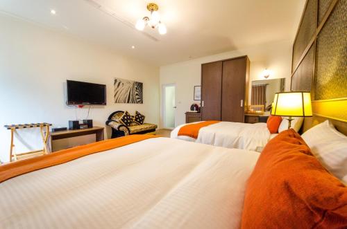 a hotel room with two beds and a television at Butchard Villas in Yuchi
