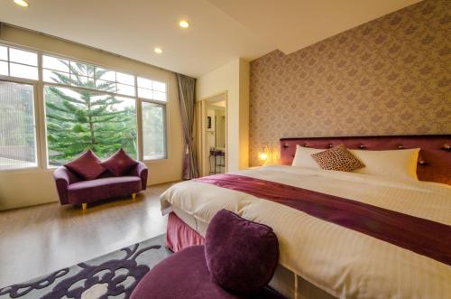 a bedroom with a large bed and a chair at Butchard Villas in Yuchi