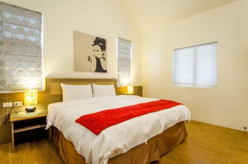 a bedroom with a large bed with a red blanket at Butchard Villas in Yuchi