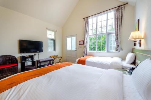 a bedroom with two beds and a tv at Butchard Villas in Yuchi