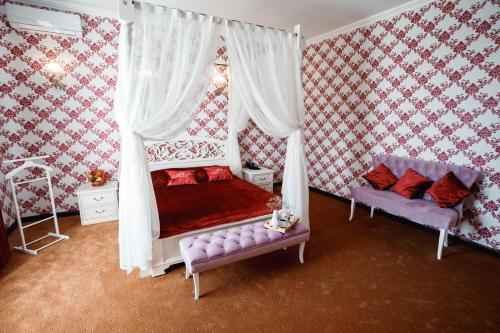 a bedroom with a canopy bed and a couch at Hotel Amfora in Vyazma