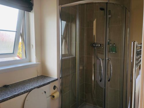 a shower with a glass door in a bathroom at Taigh d'Luxe in Inverness