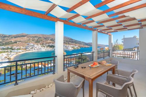 a balcony with a table and chairs and a view of the ocean at Belvedere Andros in Batsi