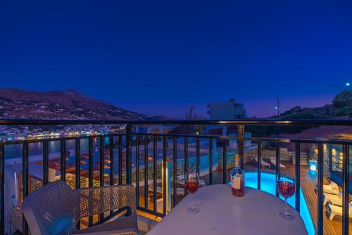 a balcony with a table and two glasses of wine at Belvedere Andros in Batsi