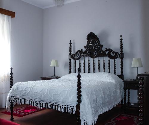 een slaapkamer met een bed met een wit dekbed bij Casa das Indrineiras in Mogadouro