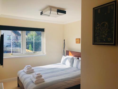 a bedroom with a bed with towels on it at Taigh d'Luxe in Inverness