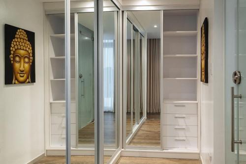 a walk in closet with glass doors and a mirror at Beach House Zambales in San Antonio