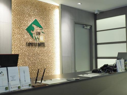 an office with a reception desk with a sign on a wall at LEO YU Capsule Hotel Nishifunabashi in Funabashi
