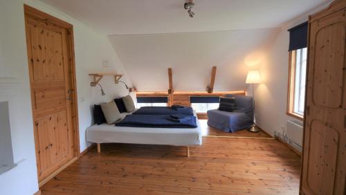 a bedroom with a bed and a couch in a room at Villa Vilan - Countryside Lodging in Skillingaryd