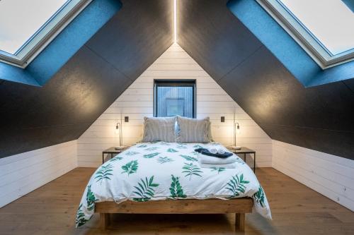 a bedroom with a bed in a attic at Eco Black Hut in Christchurch