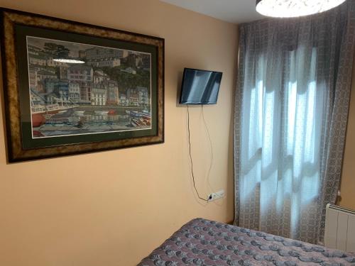 - une chambre avec une photo, un lit et une fenêtre dans l'établissement EL CAMBARAL del PUERTO, à Luarca