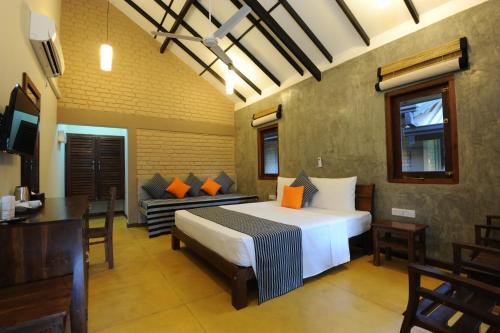 - une chambre avec un lit, une table et des chaises dans l'établissement Melheim Beach Kalpitiya, à Kalpitiya